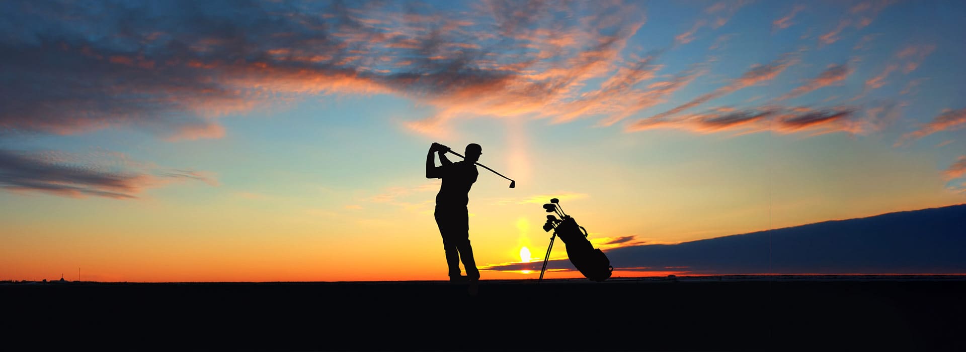 Golfer posing after hitting an iron show near dusk. Shelter Cove CA Golf